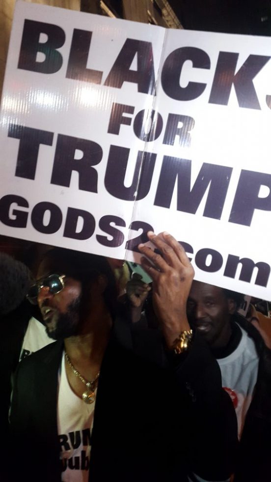 Afro-Amerikaanse aanhangers van Donald Trump vieren zijn verkiezingswinst tegenover het New York Hilton Midtown. Foto Hans Klis