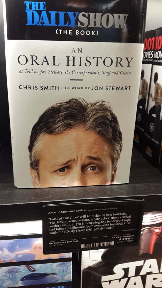 Het boek The Daily Show (The Book): An Oral History in de Amazon Book Store in New York. Met klantenrecensie in de schappen. Foto Hans Klis